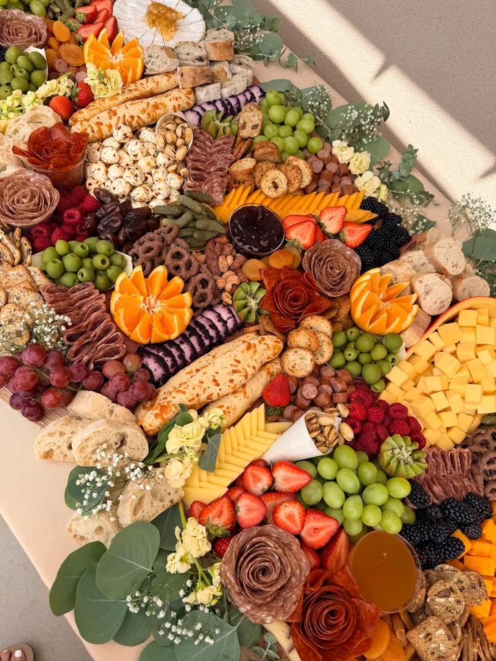 Colorful Curated Board grazing display with fruit, cheese, charcuterie, bread, and floral details